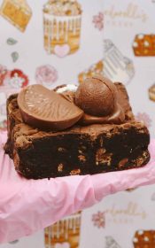 A gluten-free Terry's chocolate orange brownie topped with a glossy layer of chocolate orange. The brownie is rich and fudgy, with a deep brown color, while the topping features a vibrant orange hue, showcasing the combination of chocolate and citrus flavors.